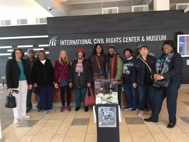 Members of the association standing together inside the International Civil Rights Center & Museum